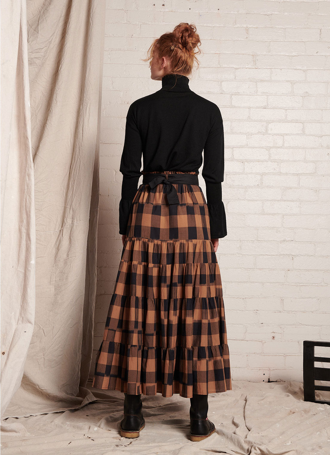 A bronze plaid, tiered, maxi skirt with elasticated waist and gathered detail made from handwoven ikat cotton