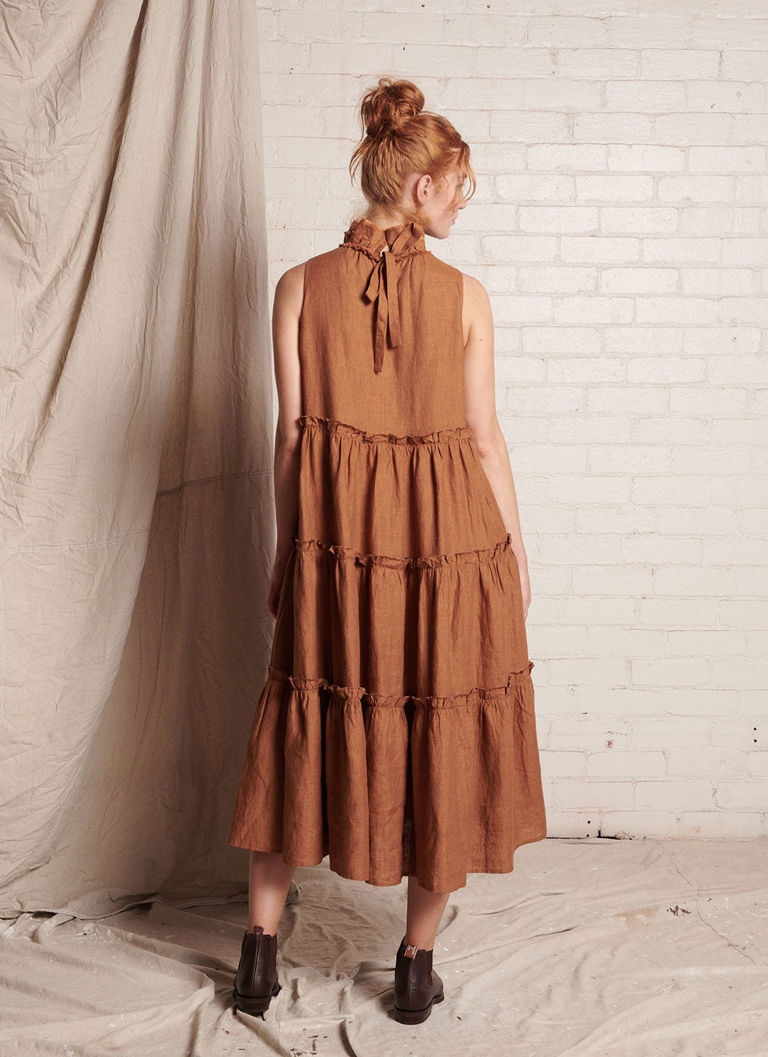 A bronze, sleeveless, pure European linen, tiered dress with ruffled collar and detailing