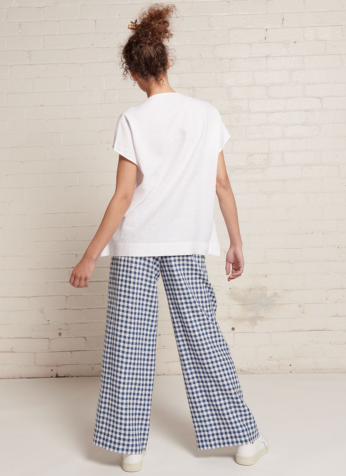 An indigo and white gingham, wide-leg pants with wide and elasticated back waistband and side pockets in small gingham yarn dye washed linen