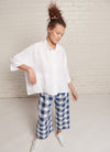 An indigo and white gingham, loose fitting crop pants with elasticated waistband and tie belt of the same fabric made from large gingham yarn dye washed linen