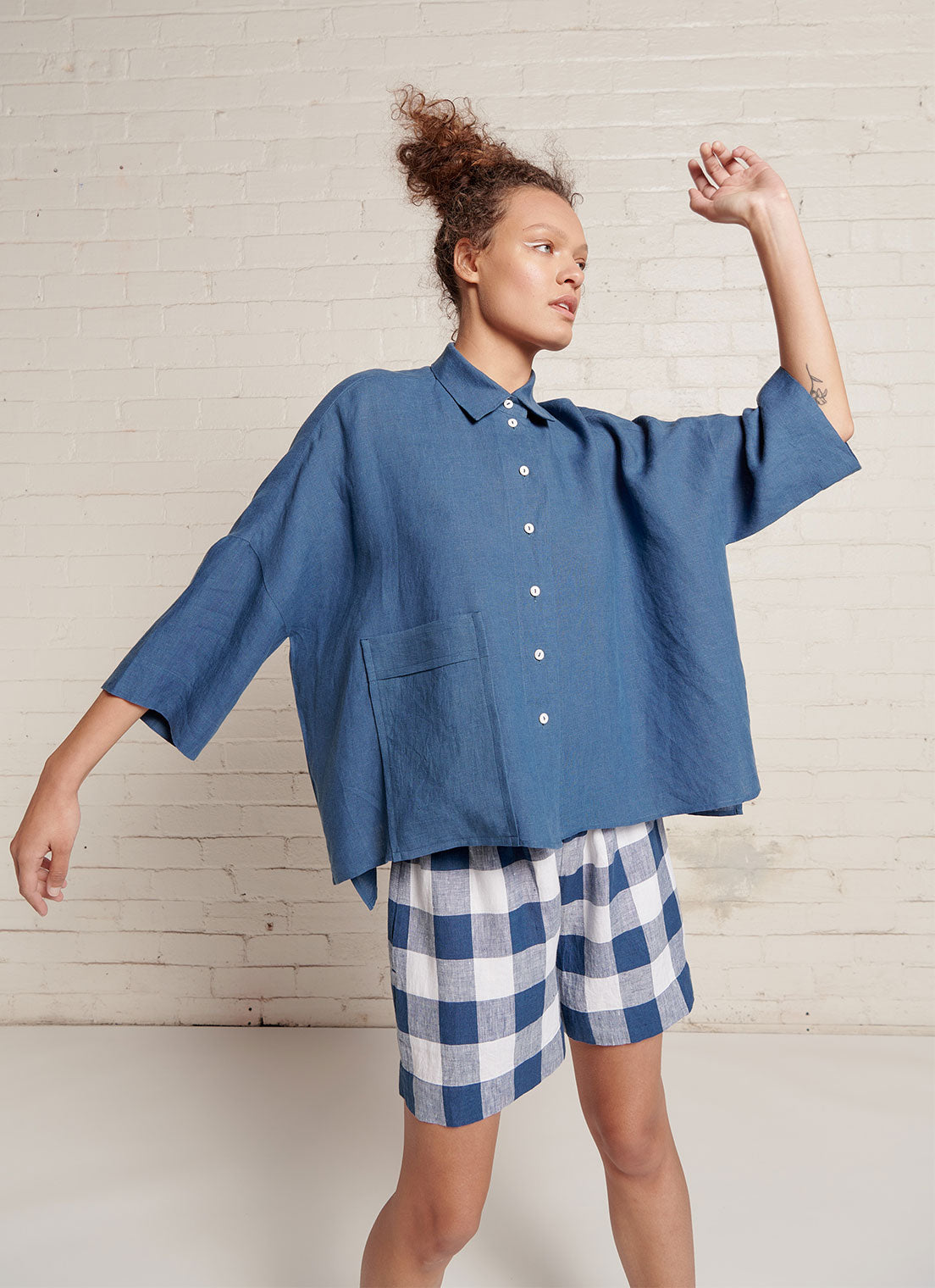 An indigo and white gingham shorts with elasticated waistband and pockets made from large gingham yarn dye washed linen